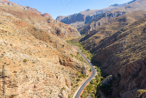 Aerial view of Naravank (Gnishek river) gorge and the road leading to Noravank Monastery on sunny autumn day. Vayots Dzor Province, Armenia.