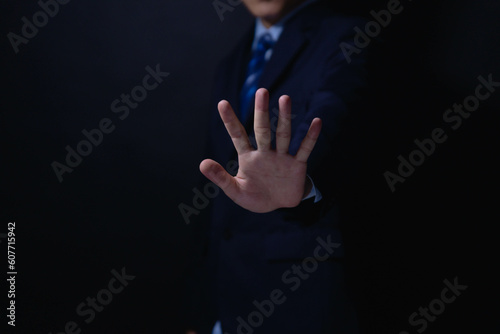 male hand showing stop gesture Concept of stop violence. Warning, prohibition, denial. On dark background.	
