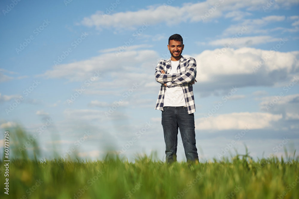 Standing with arms crossed. Handsome Indian man is on the agricultural field Standing with arms crossed. Handsome Indian man is on the agricultural field