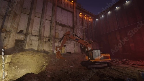 Excavator at work in night scene. Slow camera zoom.