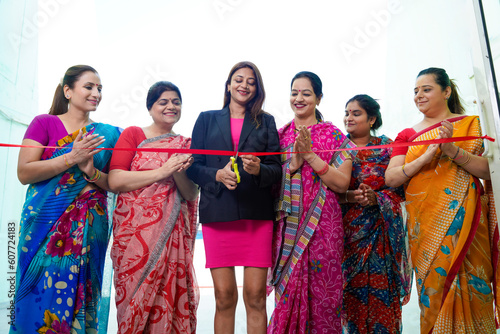 Woman entrepreneur cutting red ribbon for new start up. inauguration concept.