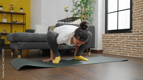 Young beautiful hispanic woman training yoga at home