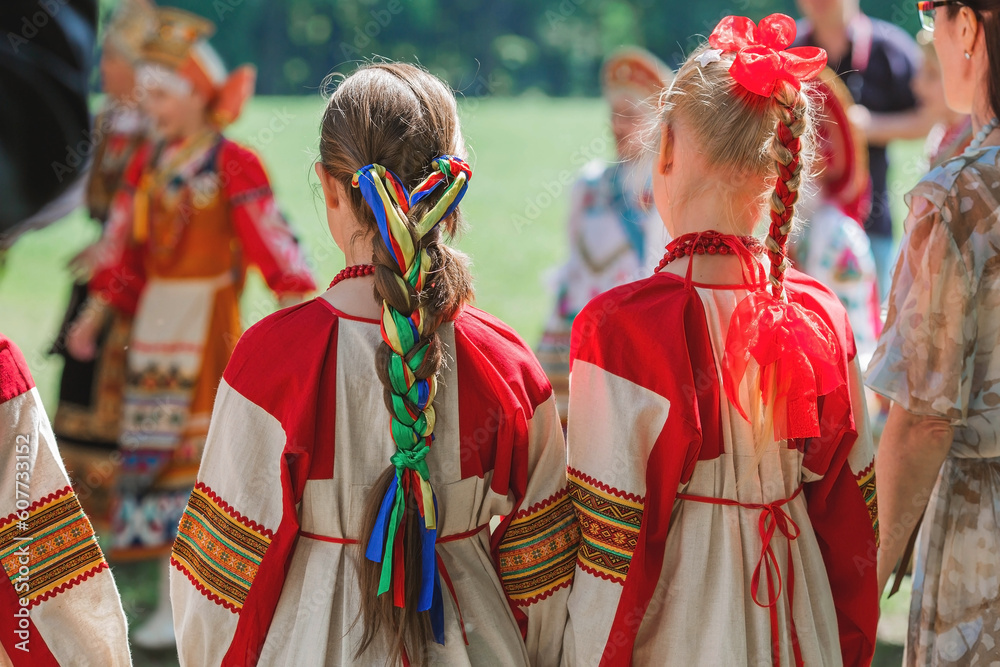 Russian folk traditions. Folk festivals. Children in beautiful Russian traditional outfits sing songs, dance and lead a round dance. National Russian clothes. Sundresses and kokoshniks.