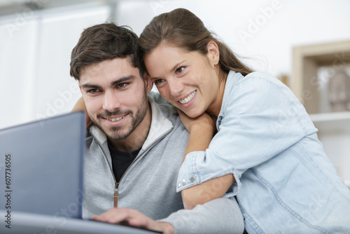 excited couple reading good news on laptop