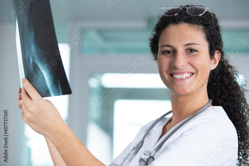 smiling female doctor studying x-ray photo