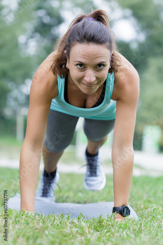 happy woman doing plank on grass