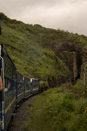 A view of a train running through a mountain in Ooty, Tamil Naidu