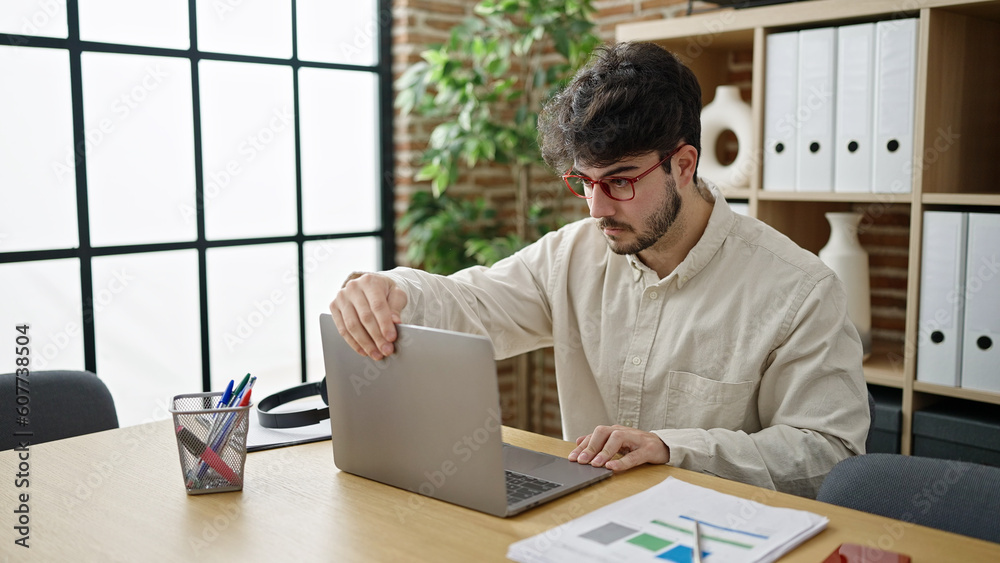 Young hispanic man business worker using laptop working at office Young hispanic man business worker using laptop working at office