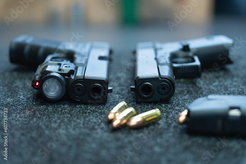 Firearms in the shooting range. Pistol with flashlight, laser sight and 9mm ammo.