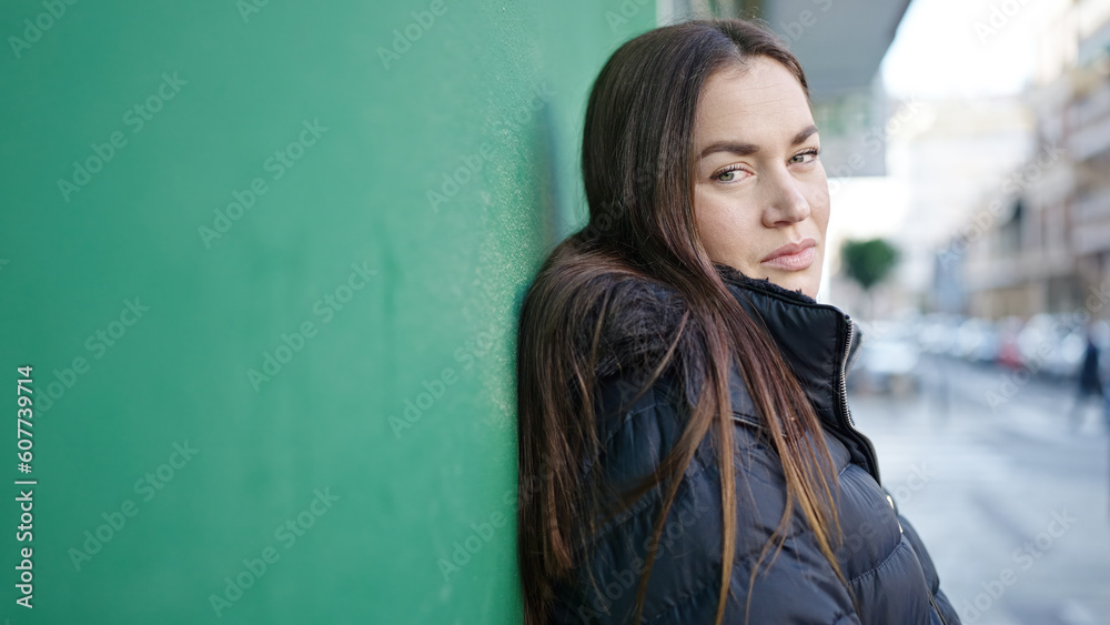 Young caucasian woman standing with serious expression at street