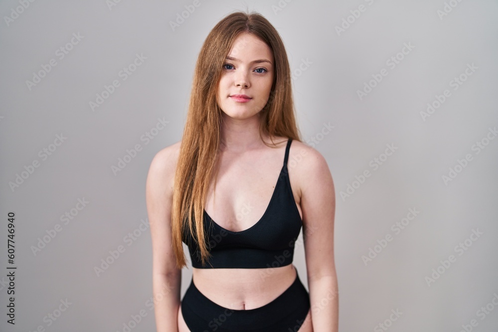 Young caucasian woman wearing lingerie relaxed with serious expression on face. simple and natural looking at the camera.