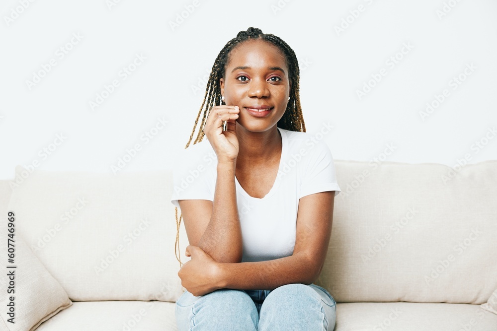 Happy african american woman sitting at home on sofa, rest and vacation smile, light background. Relaxed home lifestyle, day off. Happy african american woman sitting at home on sofa, rest and vacation smile, light background. Relaxed home lifestyle, day off.