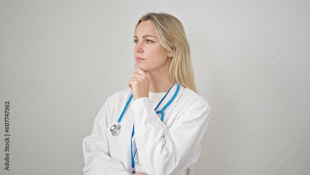 Young blonde woman doctor standing with doubt expression thinking over isolated white background Young blonde woman doctor standing with doubt expression thinking over isolated white background