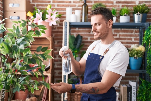Young hispanic man florist using difusser working at florist