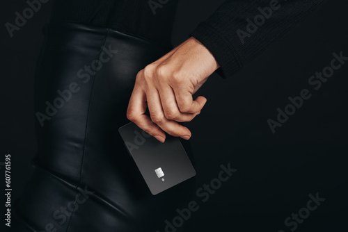 Getting a hold on the pulse of modern banking: Female hand holds a premium bank card in a studio setting
