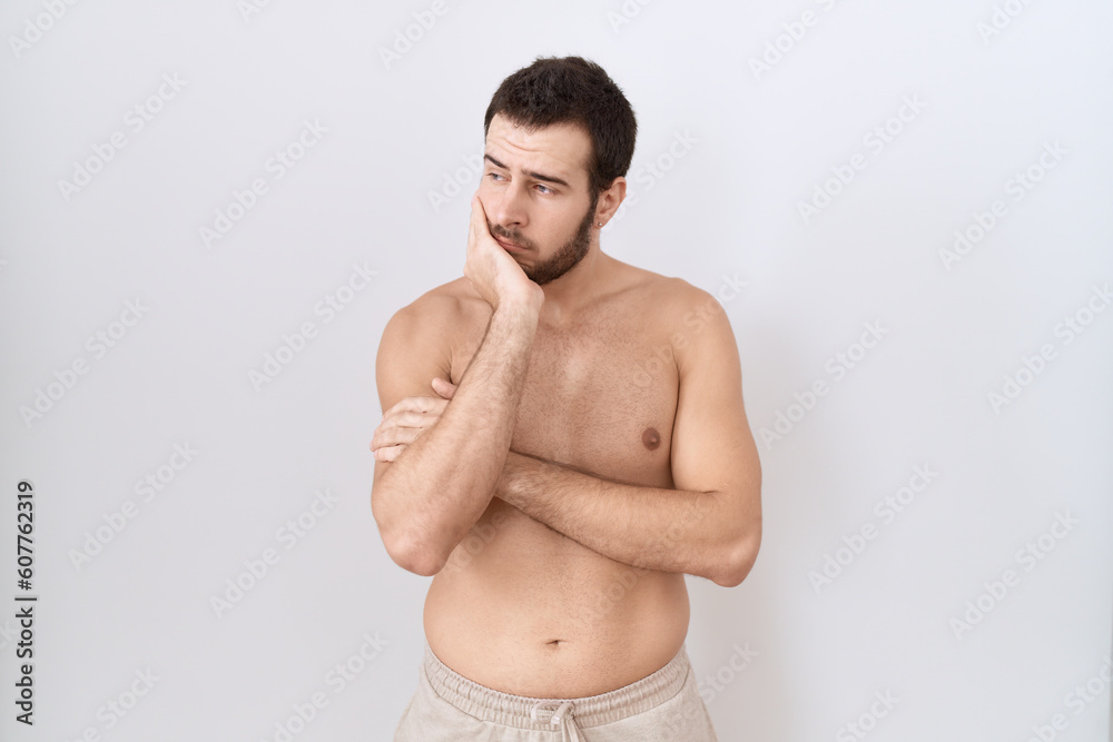 Young hispanic man standing shirtless over white background thinking looking tired and bored with depression problems with crossed arms. Young hispanic man standing shirtless over white background thinking looking tired and bored with depression problems with crossed arms.