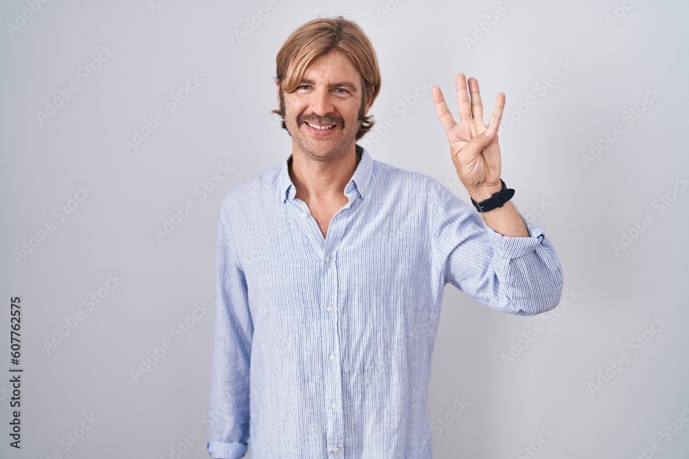 Caucasian man with mustache standing over white background showing and pointing up with fingers number four while smiling confident and happy. Caucasian man with mustache standing over white background showing and pointing up with fingers number four while smiling confident and happy.
