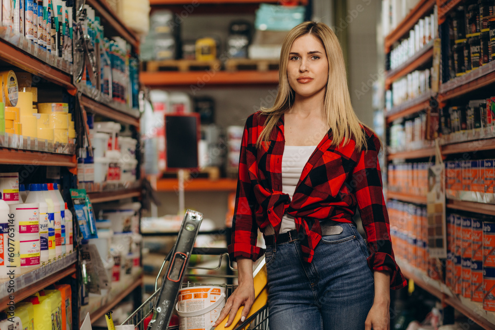 Portrait of female customer holding cellphone and screwdriver in hardware store. Portrait of female customer holding cellphone and screwdriver in hardware store.