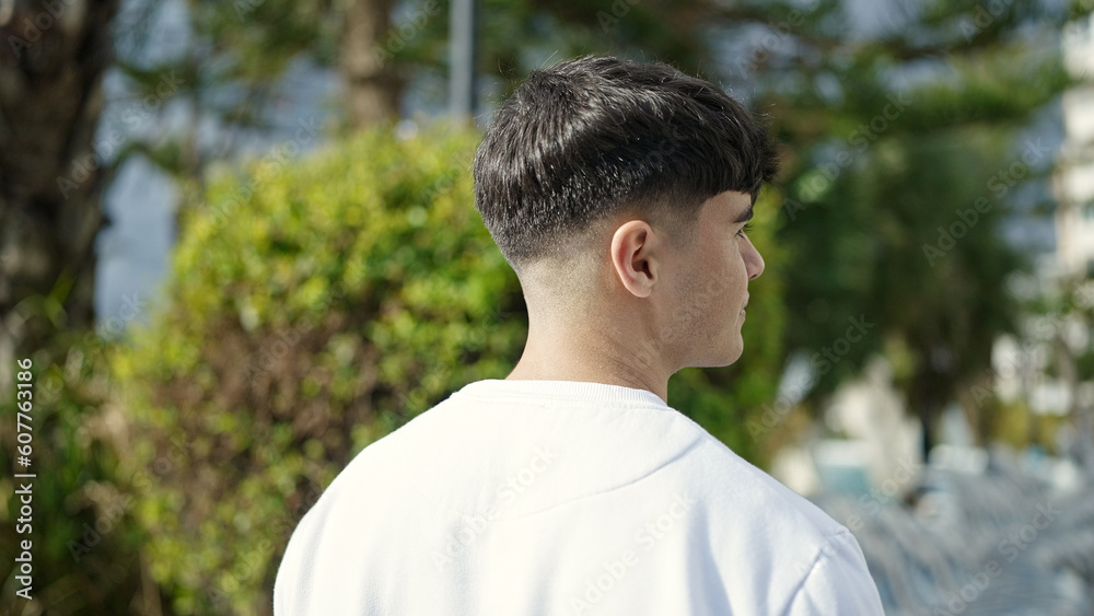 Young hispanic man standing backwards at park Young hispanic man standing backwards at park