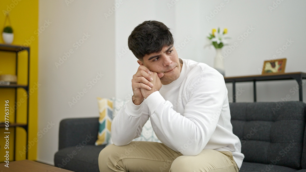Young hispanic man stressed sitting on sofa at home Young hispanic man stressed sitting on sofa at home