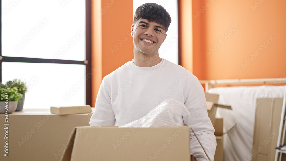 Young hispanic man smiling confident holding package at new home Young hispanic man smiling confident holding package at new home