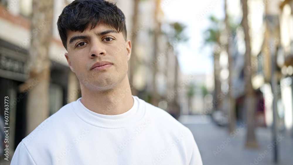 Young hispanic man standing with serious expression at street Young hispanic man standing with serious expression at street