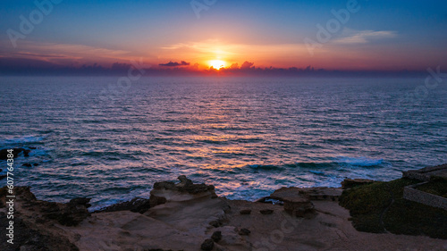 Aerial view over beautiful  ocean during  sunset. Top view to the ocean in summer day while sunset - closeup. Drone view of a Scenic slow motion ocean waves. Beautiful sunrise over ocean © Valua Vitaly