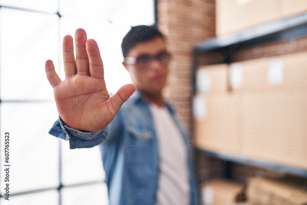 Down syndrome man ecommerce business worker doing stop sign with hand at office Down syndrome man ecommerce business worker doing stop sign with hand at office