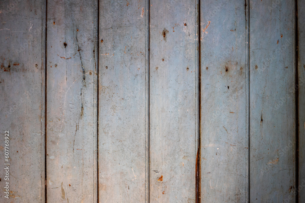 A background of rough, pitted wooden boards. A gray brown wooden facade. A background of rough, pitted wooden boards. A gray brown wooden facade.