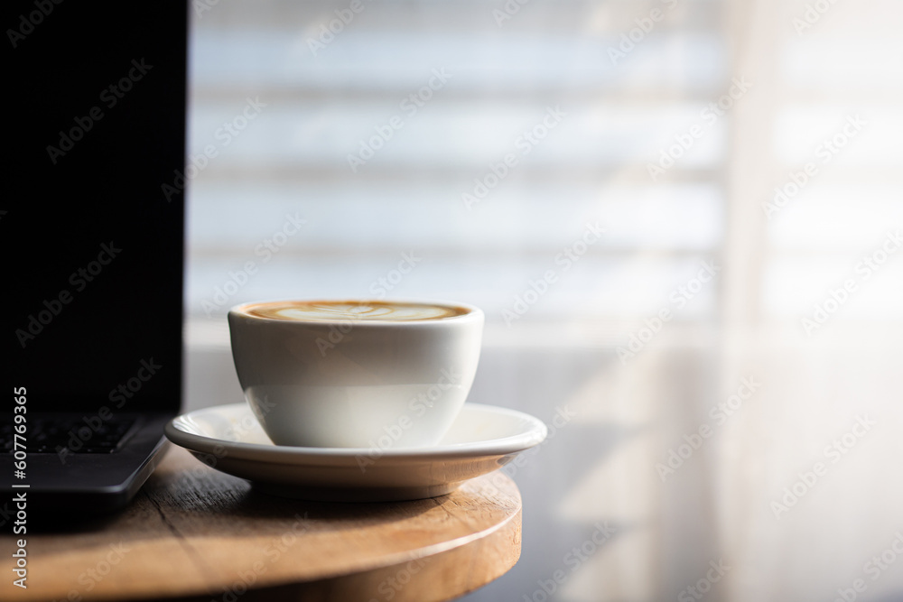 Start your working day with hot latte coffee cup background, laptop and mobile phone at work.