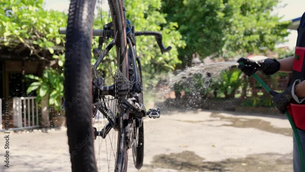 Asian bike mechanic washing a customer's bike.