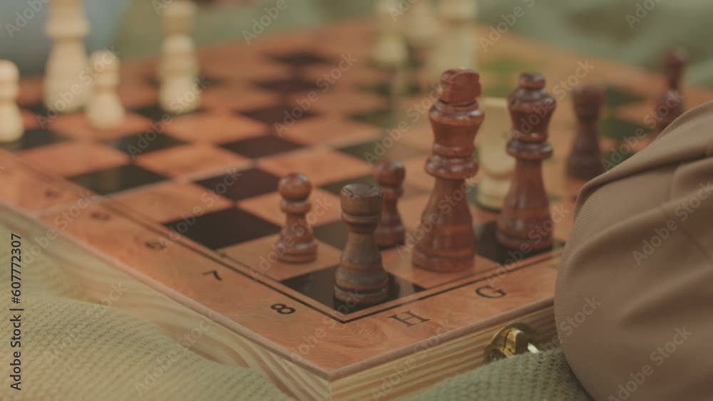 Close up of unrecognizable man making checkmate move during outdoor chess game with friend