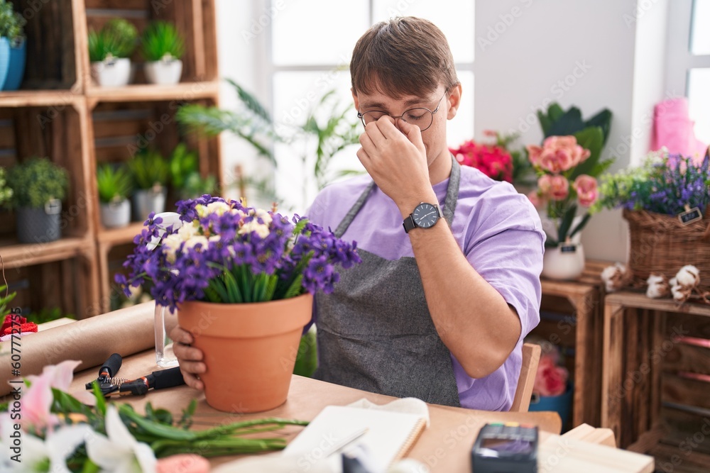 Caucasian blond man working at florist shop tired rubbing nose and eyes feeling fatigue and headache. stress and frustration concept.