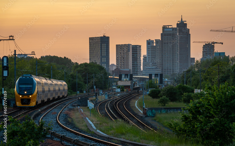 Skyline of Amsterdam by sunset, modern office buildings seen from the railway at dusk