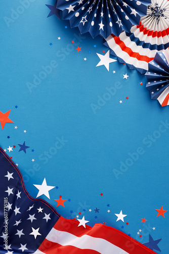 4th of July celebration concept. Top view flat lay of american flag, patriotic folding fans, star-shaped confetti on blue background with empty space for text or ads