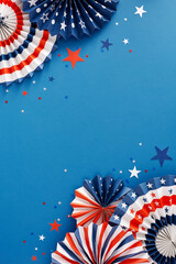 Party concept for celebrating American Independence Day. Top view flat lay of paper party props, patriotic confetti on blue background with blank space for text or promotion