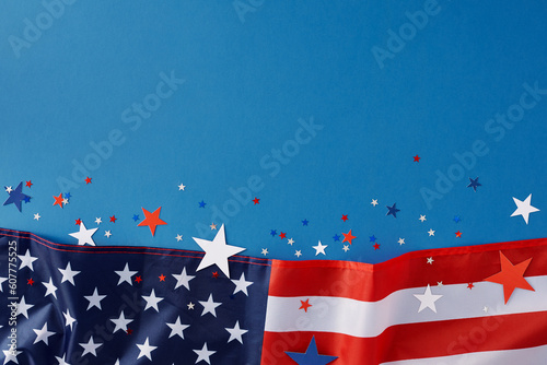 Celebration concept for America's Independence Day. Top view flat lay of national flag and blue, red, white stars on blue background with blank space for text or promotion