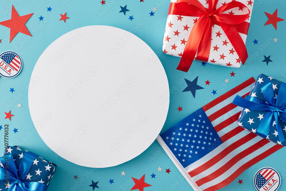 Obraz premium Fourth of July celebration theme for a party. Top view flat lay of gift boxes, american flag and star-shaped confetti on pastel blue background with blank circle for text or advert