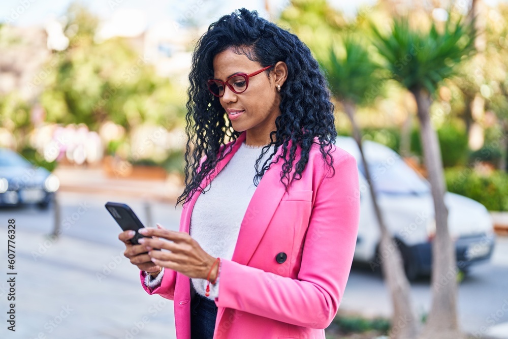 Fototapeta premium African american woman executive using smartphone at park