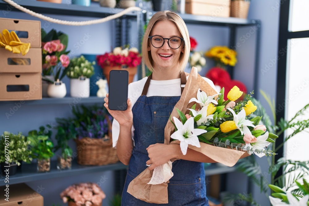 Young caucasian woman working at florist shop showing smartphone screen smiling with a happy and cool smile on face. showing teeth.