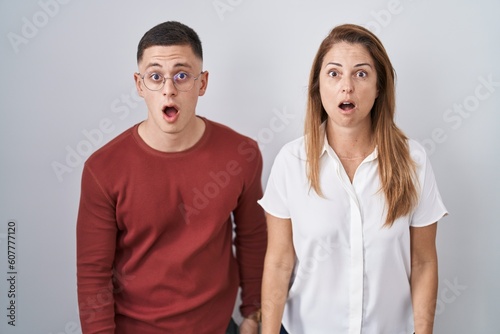 Mother and son standing together over isolated background afraid and shocked with surprise and amazed expression, fear and excited face.