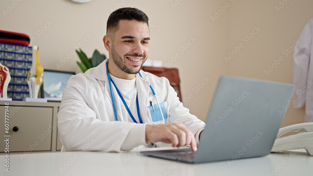 Young hispanic man doctor using laptop working at clinic Young hispanic man doctor using laptop working at clinic