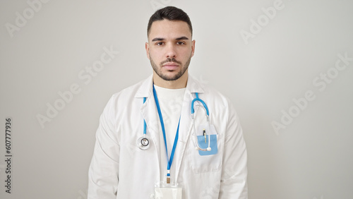 Young hispanic man doctor standing with serious expression over isolated white background © Krakenimages.com