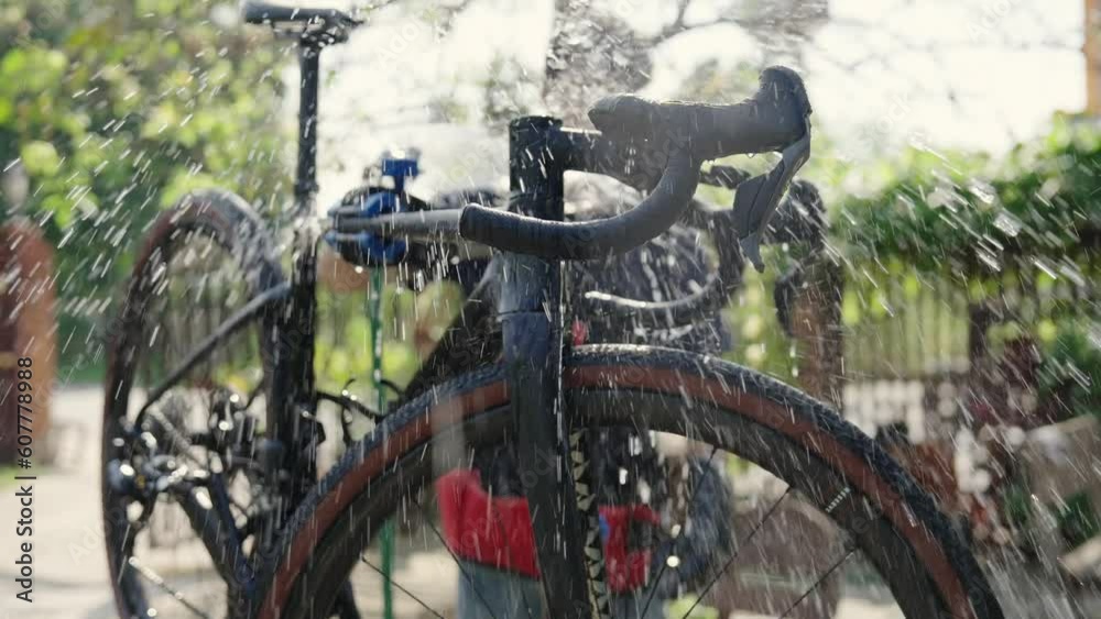 Asian bike mechanic washing a customer's bike. Asian bike mechanic washing a customer's bike.