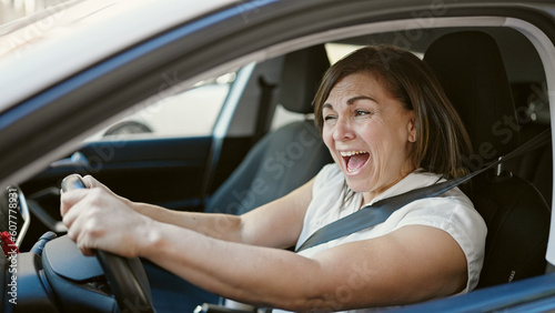 Middle age hispanic woman stressed driving car at street © Krakenimages.com