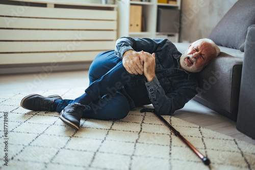 Senior man falling on the ground with walker in living room at home. Elderly older mature male having an accident heart attack for emergency help support from hospital. Insurance health care. © Dragana Gordic