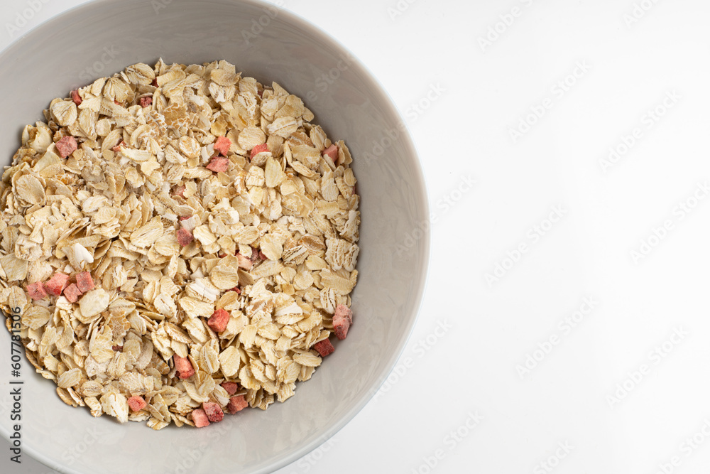 Fresh healthy breakfast of oatmeal and cereal with strawberries in a blue bowl on a white background isolate Fresh healthy breakfast of oatmeal and cereal with strawberries in a blue bowl on a white background isolate