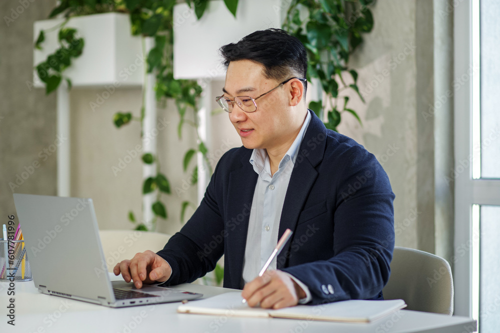 Smiling asian businessman working, using laptop. Human resources. Finance concept. Multiracial Smiling asian businessman working, using laptop. Human resources. Finance concept. Multiracial