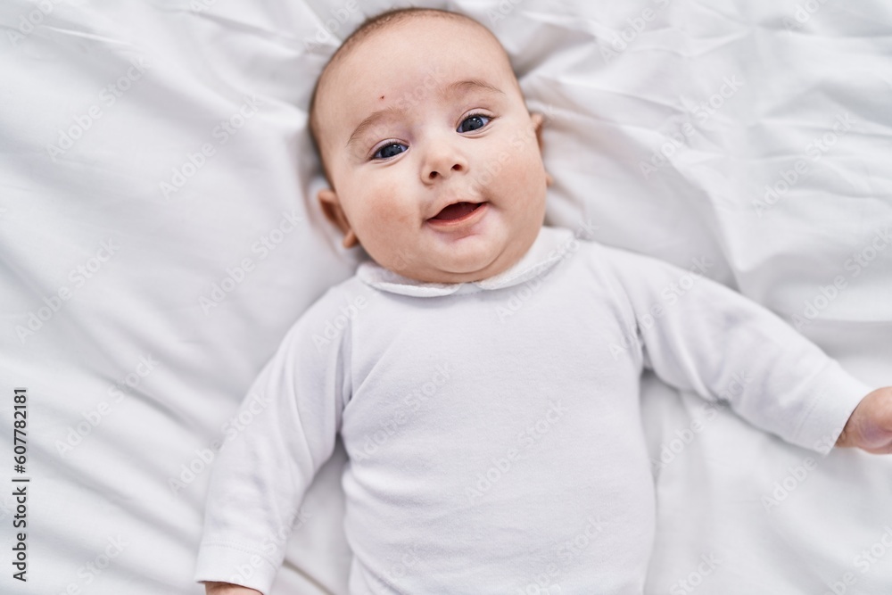 Adorable baby smiling confident lying on bed at bedroom Adorable baby smiling confident lying on bed at bedroom