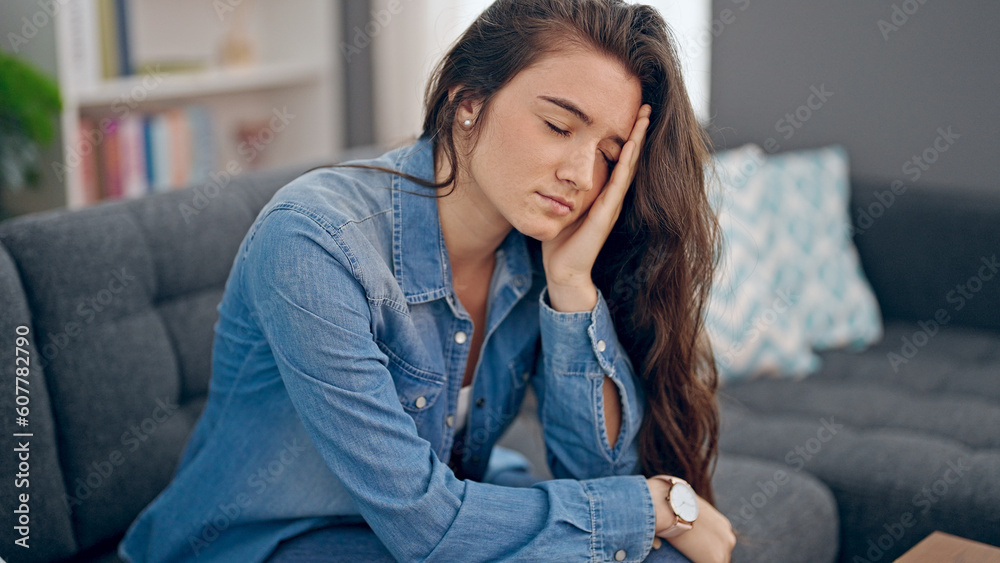 Young beautiful hispanic woman sitting on sofa with serious expression at home Young beautiful hispanic woman sitting on sofa with serious expression at home